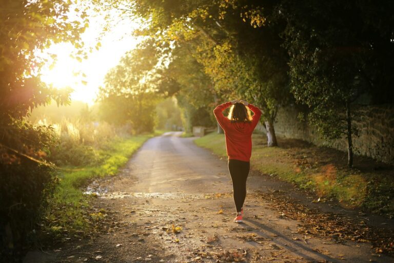 “woman finishing a run at sunset, no longer afraid to cut back on running and feeling calm and strong”