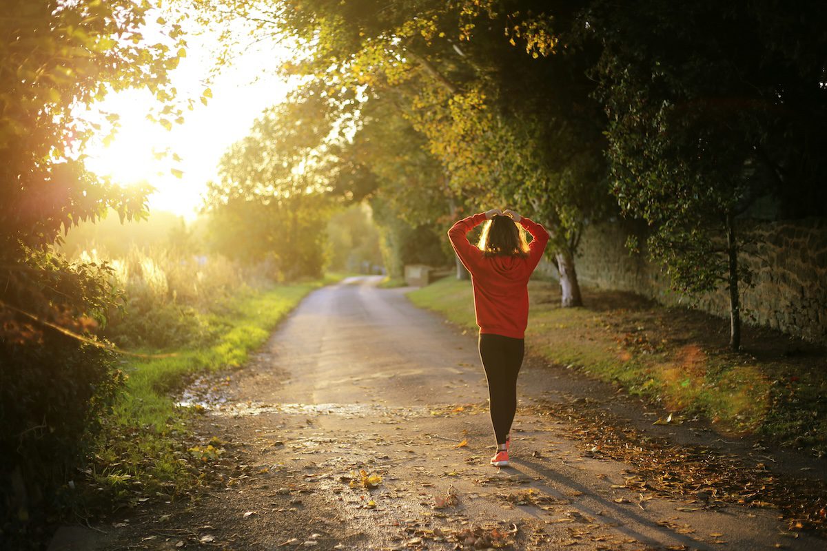 “woman finishing a run at sunset, no longer afraid to cut back on running and feeling calm and strong”