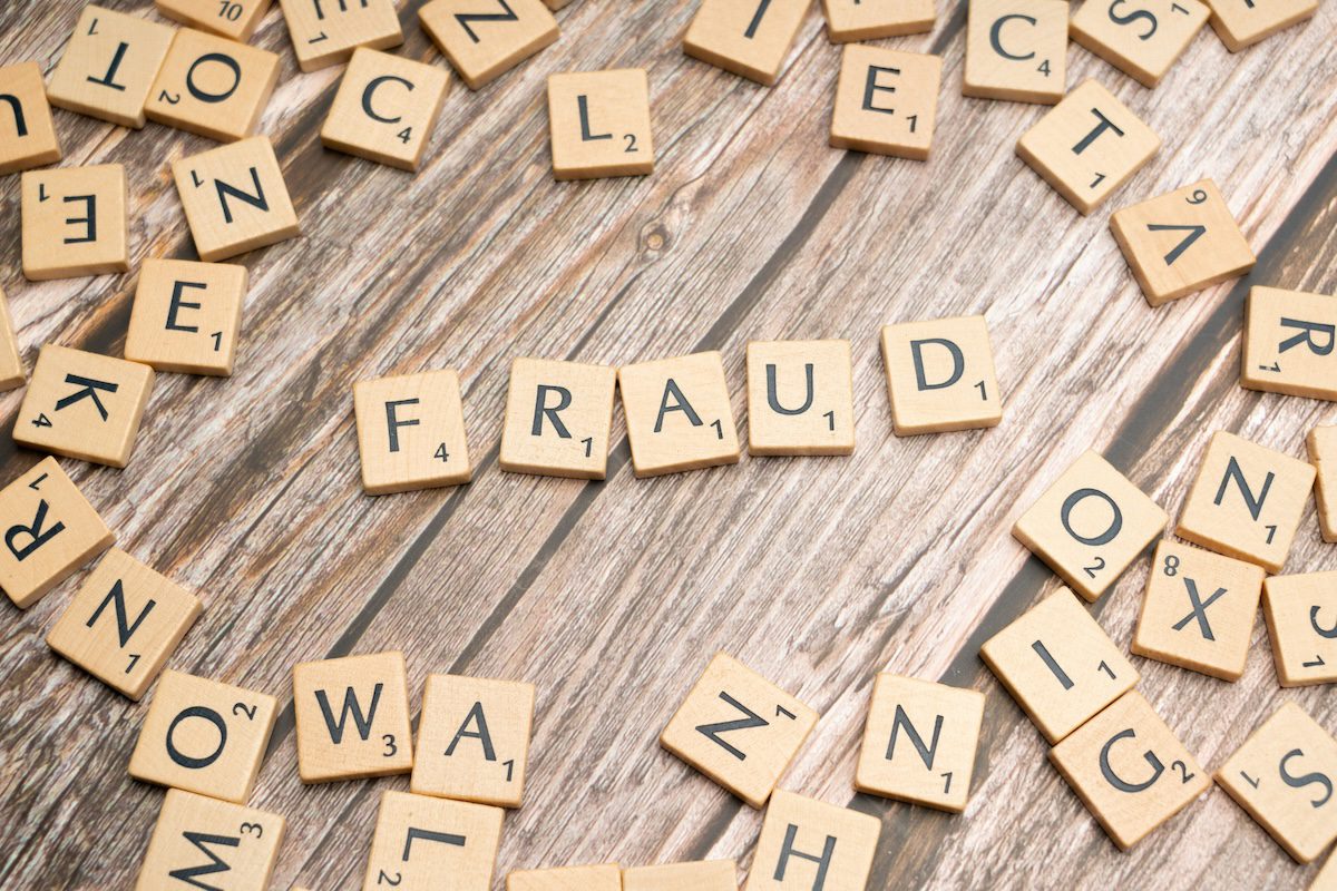Scrabble letters spelling ‘fraud,’ symbolizing imposter syndrome in grief.