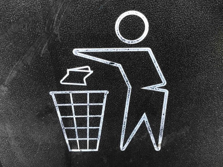 Line drawing of a person throwing paper into a trash bin, representing tossing out old goals or expectations.