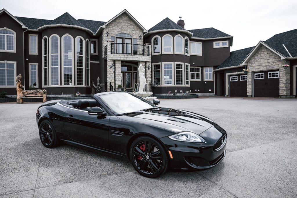 “Expensive car and large home representing high-cost lifestyle decisions”