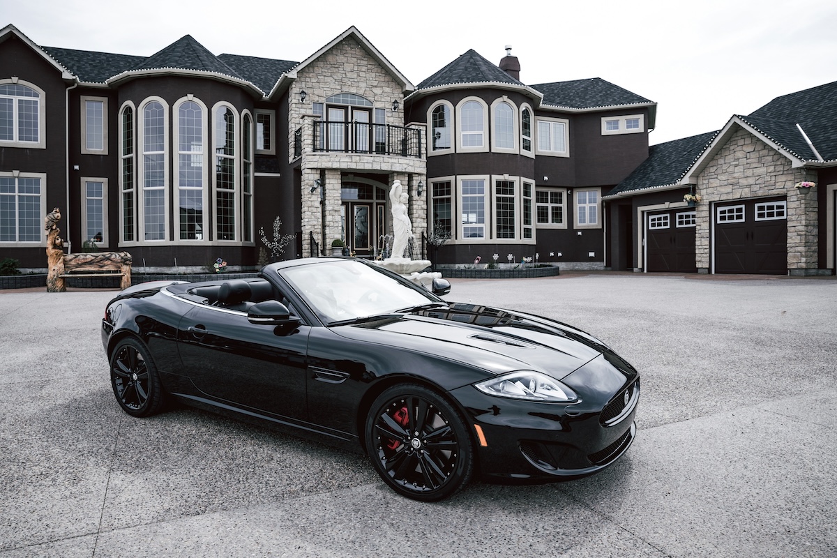 “Expensive car and large home representing high-cost lifestyle decisions”