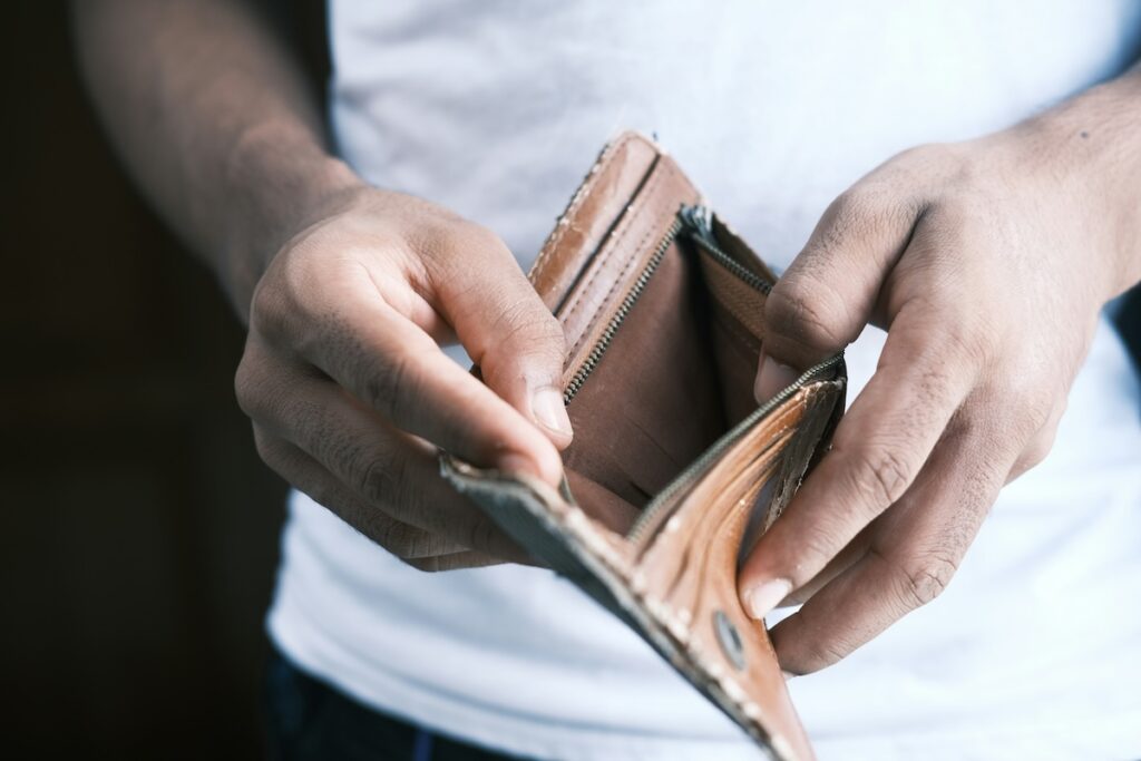 Person holding an empty wallet, representing the feeling of still being broke after getting a raise